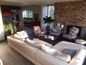 ein Wohnzimmer mit einer weißen Couch und einem Kamin in der Unterkunft Maison Vintage Ardenne in Awenne