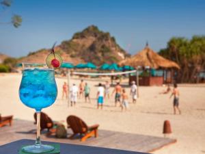 a drink sitting on a table at the beach at Novotel Lombok Resort & Villas in Kuta Lombok