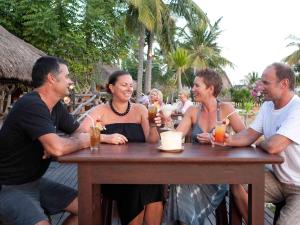 a group of people sitting at a table with drinks at Novotel Lombok Resort & Villas in Kuta Lombok