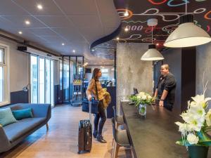 Ein Mann und eine Frau stehen in einem Büro mit einem Tisch. in der Unterkunft ibis Lille Villeneuve-d'Ascq Grand Stade in Villeneuve d'Ascq