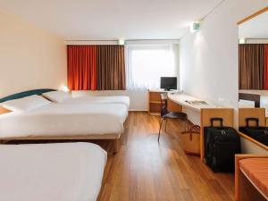 ベルリンにあるイビス ベルリン メッセのベッド2台とデスクが備わるホテルルームです。