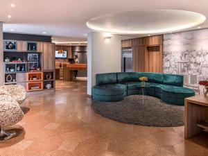 a living room with a green couch and a table at Mercure Sao Paulo Alamedas in São Paulo