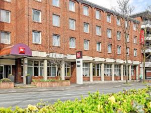 um grande edifício de tijolos vermelhos numa rua em ibis Paderborn City em Paderborn