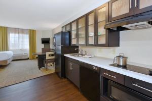 a kitchen with a sink and a refrigerator in a room at Candlewood Suites Polaris, an IHG Hotel in Columbus