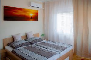 - un lit dans une chambre avec une photo sur le mur dans l'établissement Joe Beach Apartman, à Keszthely