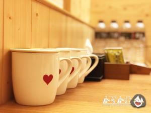 una fila de tazas de café alineadas en un mostrador en 沐馨溫泉民宿, en Jiaoxi