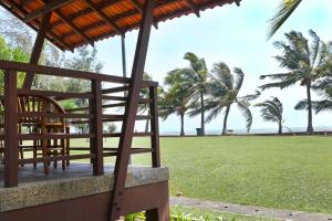 - une vue sur la plage depuis la terrasse couverte d'un complexe avec des palmiers dans l'établissement Villea Morib, à Morib