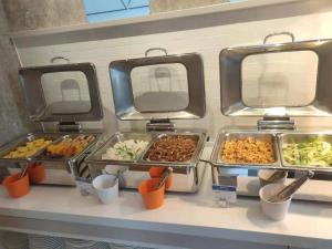 a buffet with several trays of food on a counter at Holiday Inn Express Shanghai Kangqiao, an IHG Hotel in Shanghai