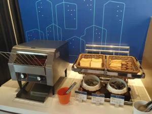 a food stand with a grill and some pastries at Holiday Inn Express Shanghai Kangqiao, an IHG Hotel in Shanghai