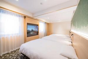 Postel nebo postele na pokoji v ubytování Matsuyama Tokyu REI Hotel