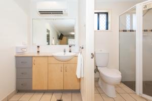 a bathroom with a toilet and a sink at Coral Cay Resort in Mackay