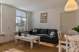 a living room with a couch and a table at Appartement Torenzicht - Leeuwarden in Marssum
