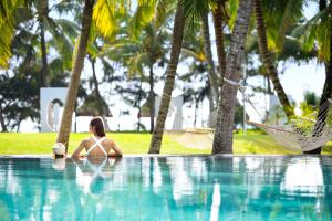 una mujer en bikini sentada en una piscina en Raffles Hainan Clear Water Bay, en Sanya