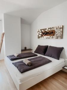 2 Betten in einem Schlafzimmer mit weißen Wänden in der Unterkunft Lake View Apartment Seecorso in Velden am Wörthersee