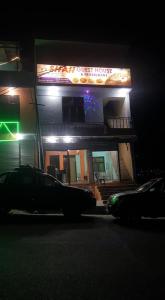 un bâtiment avec un panneau sur son côté la nuit dans l'établissement Shah Guest House, à Gilgit