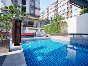 
a large swimming pool in a large building at The Grass Serviced Suites in Pattaya
