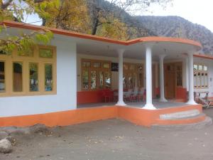 a house with an orange roof and a porch at Benazir Hotel Kalash 