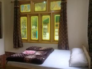 a bedroom with a bed and a window at Benazir Hotel Kalash 