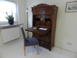 uma secretária de madeira antiga e uma cadeira num quarto em Ferienwohnung Burgenblilck em Weinheim
