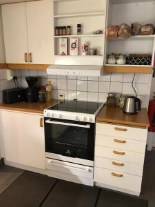 耶夫勒的住宿－Gävle Bed & Breakfast，厨房配有白色橱柜和炉灶烤箱。