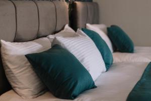 a couch with green and white pillows on it at Melrose House Hotel in Pamukkale