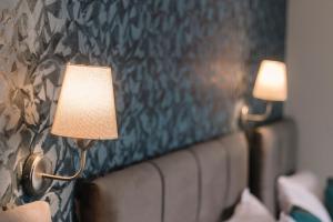 a pair of lights on a wall next to a bed at Melrose House Hotel in Pamukkale