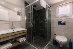 a bathroom with a shower and a toilet and a sink at Melrose House Hotel in Pamukkale