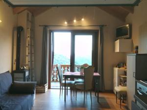 a living room with a table and chairs and a window at LA PICCIONAIA in Varallo