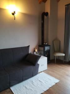 een woonkamer met een bank en een stoel bij LA PICCIONAIA in Varallo