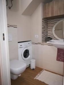 een badkamer met een wasmachine en een wastafel bij LA PICCIONAIA in Varallo