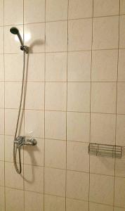 a shower in a tiled wall with a shower head at Raasiku Hotell in Raasiku