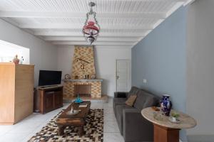 ein Wohnzimmer mit einem Sofa und einem Tisch in der Unterkunft Pousada Barão do Javary in Miguel Pereira