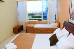 - une chambre avec 2 lits et une grande fenêtre dans l'établissement Apartment in Cartagena in front of the sea 1C11, à Carthagène des Indes