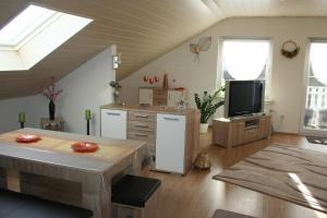 ein Wohnzimmer mit einer Küche und einem TV in der Unterkunft Ferienwohnungen Alt in Naumburg