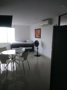 Zimmer mit einem Tisch, Stühlen und einem Bett in der Unterkunft Apartment in Cartagena Ocean Front 1C5 in Cartagena de Indias