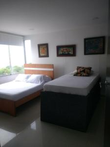 2 Einzelbetten in einem Zimmer mit Fenster in der Unterkunft Apartment in Cartagena Ocean Front 1C5 in Cartagena de Indias