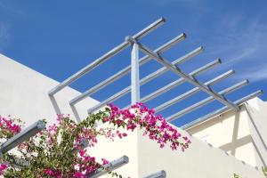 awning over a white building with pink flowers at Atlantis Beach Villa in Perivolos