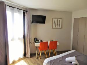 a bedroom with a bed and a table and two chairs at Auberge de la Paillère in Lavours