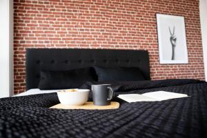 Tolles Apartment mit Weitblick über Augsburg في اوغسبورغ: سرير أسود مع وعاء من الطعام وكوب عليه