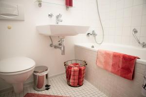 een badkamer met een wastafel, een toilet en een bad bij Tolles Apartment mit Weitblick über Augsburg in Augsburg