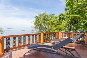 two chairs sitting on a deck overlooking the water at Phi Phi Natural Resort-SHA Extra Plus in Phi Phi Islands