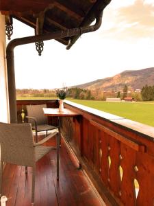 a deck with a table and chairs and a field at Apartment Beim Raffner in Ruhpolding
