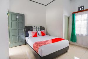 1 dormitorio con cama y puerta verde en OYO 2903 Putri Residence Syariah en Bukittinggi