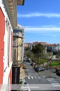 a building with bikes parked on a balcony next to a street at Hôtel & Espace Bien-être La Maison du Lierre in Biarritz