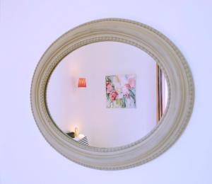a mirror on a white wall with a picture in it at Hôtel & Espace Bien-être La Maison du Lierre in Biarritz