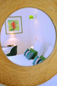 a bedroom with a bed with pillows and a mirror at Hôtel & Espace Bien-être La Maison du Lierre in Biarritz
