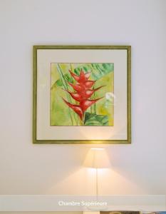 a framed painting of a red flower on a wall at Hôtel & Espace Bien-être La Maison du Lierre in Biarritz