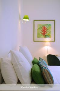 a pile of pillows on a bed in a room at Hôtel & Espace Bien-être La Maison du Lierre in Biarritz