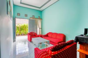 una sala de estar con sofás rojos y una mesa. en OYO 2903 Putri Residence Syariah en Bukittinggi