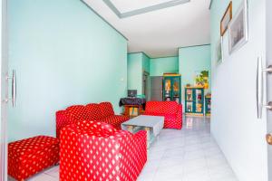 Zimmer mit roten Stühlen und einem Tisch in der Unterkunft OYO 2903 Putri Residence Syariah in Bukittinggi